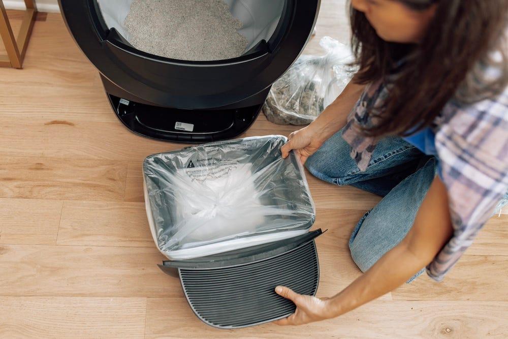 Litter-Robot 4 の廃棄ドロワーにライナーをかけている人