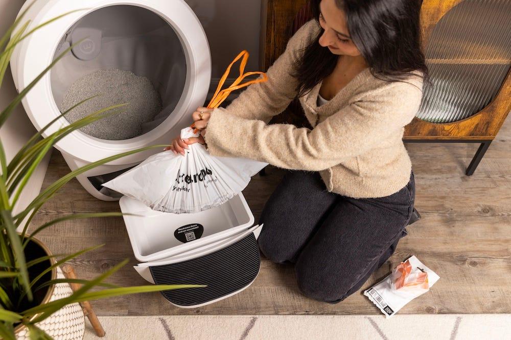 自動猫トイレの廃棄ドロワーにライナーを取り付けている手元