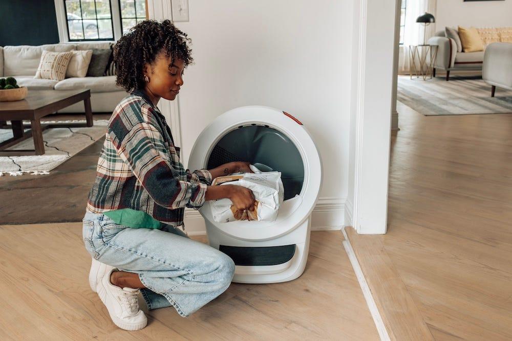 Litter-Robot 4 に猫砂を入れている人